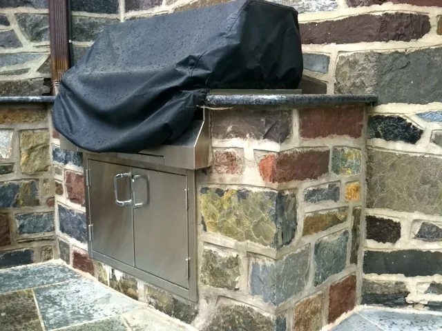 Custom stone outdoor kitchen island with a granite countertop